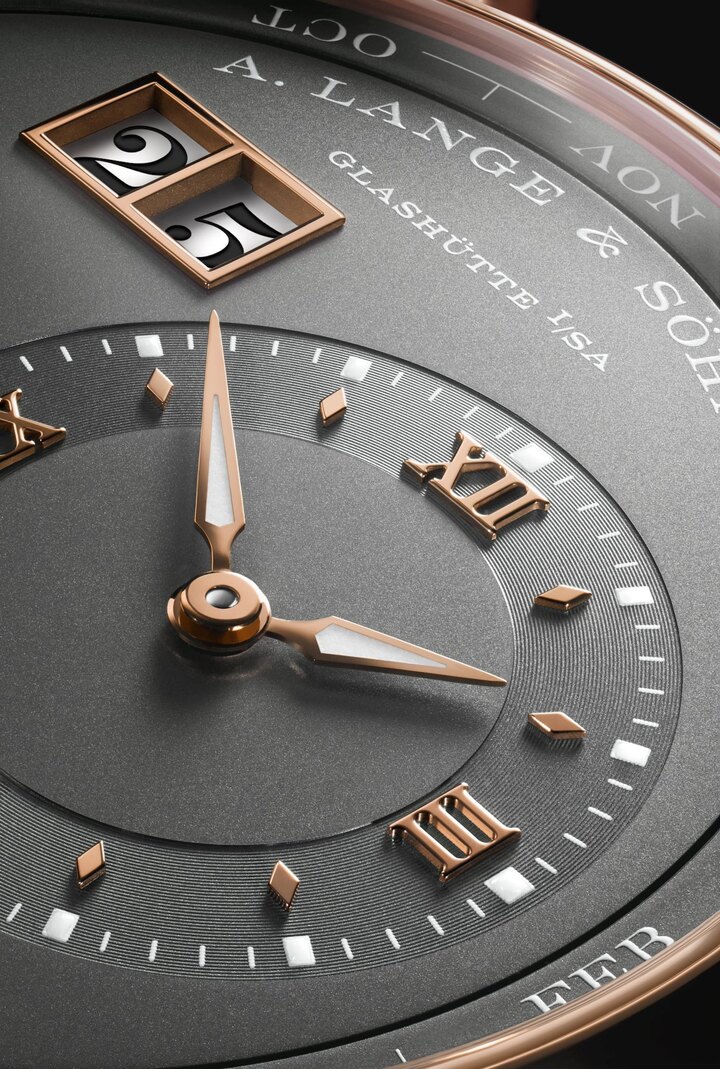 Détails de la Lange 1 Perpetual Calendar en or rose. Cadran grené gris anthracite, aiguilles, index et double fenêtre de la grande date en or rose également.