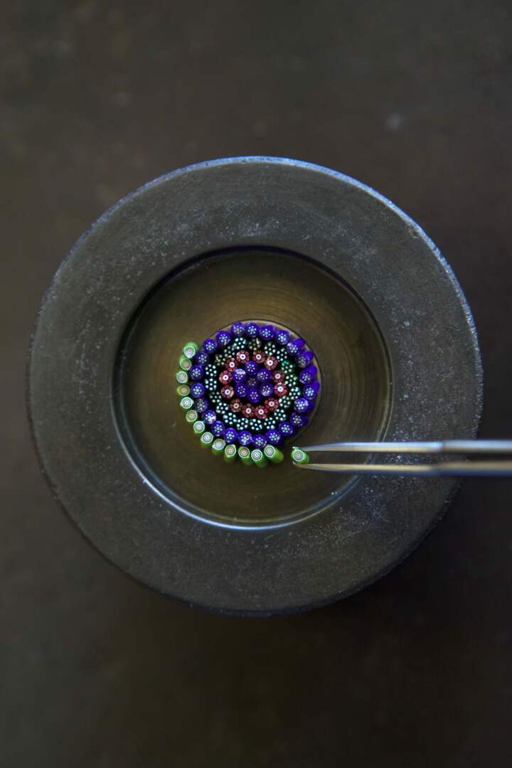 Préparation d'un cadran en cristal Millefiori destiné à la montre Arceau Millefiori (2015). Cette multitude de petits «sucres d'orge» en cristal est réalisée selon la technique des presse-papiers du 19ème siècle dans les Cristalleries royales de Saint-Louis. Une fois le bouquet polichromé achevé, il sera ensuite encapsulé dans du cristal translucide, suggérant ainsi un «parterre de fleurs».