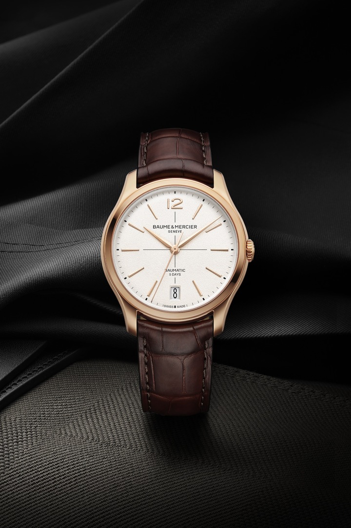 Puisant leur inspiration dans l'essence pure du design des années 1950 et constituant le haut de gamme de Baume & Mercier, les nouvelles montres Clifton Baumatic dévoilées lors de Watches & Wonders 2025 donnent un avant-goût de l'ensemble de la collection qui sera lançée en septembre. Les proportions et les finitions de la boîte ont été retravaillées sur un diamètre de 39 mm pour une épaisseur réduite à 11,5 mm. Les chiffes arabes ont été réintroduits à 12h. Les index ont été allongés. Le disque de date s'affiche dans un grand guichet à 6h et dans une nouvelle police. Le verre saphir supérieur est bombé, reprenant les codes du modèle d'inspiration de la collection. La couronne est intégrée et affinée.