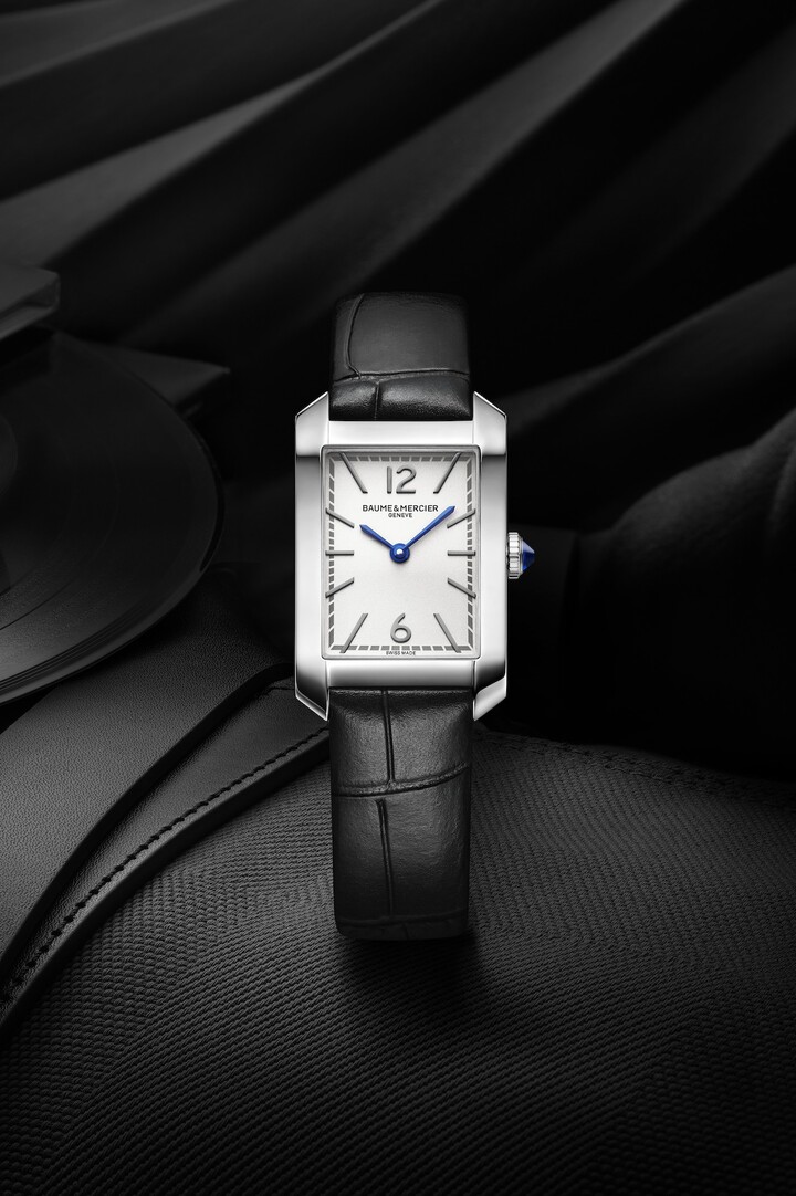 Lancée en 1994, la collection Hampton a été revisitée dans de fines proportions de 35 x 22,2 mm pour 6,92 mm d'épaisseur. Cadran opalin argenté, chiffres arabes rhodiés placés à 12h et à 6h, index rivés rhodiés, aiguilles de forme glaive bleues et minuterie grise. Mouvement à quartz d'une autonomie de six ans. 