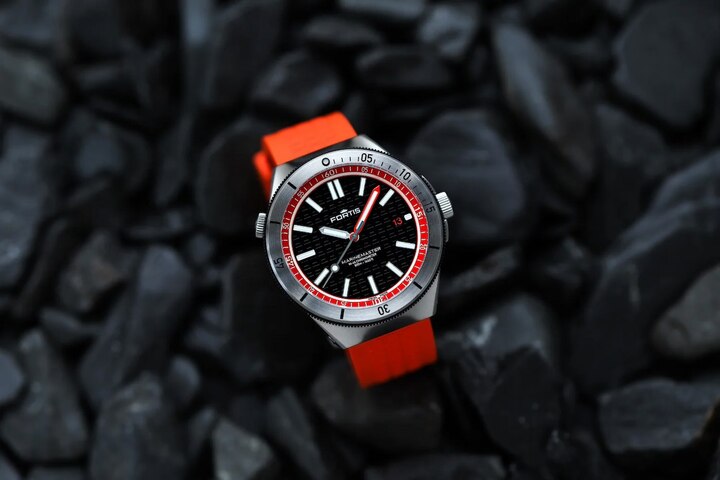  La Marinemaster M-44, et sa couleur Amber Orange, au cadran doté d'index et de logos appliqués à la main, tous imprégnés de Super-LumiNova X1 pour une meilleure visibilité. Lunette fonctionnelle Gear Bezel™. Calibre manufacture Kenissi Werk 11 certifié COSC.