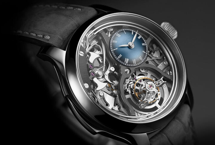 Endeavour Minute Repeater Cylindrical Tourbillon Skeleton: une répétition minutes entièrement squelettisée, avec son mécanisme au premier plan, associée à un tourbillon volant muni d'un spiral cylindrique. Deux sommets de l'horlogerie traditionnelle réunis dans une même pièce à l'architecture résolument contemporaine, au cœur d'un boîtier en titane de 40 mm de diamètre. À 14 heures, un petit cadran bombé, le fameux Funky Blue fumé de H. Moser & Cie., comme une signature secrète.