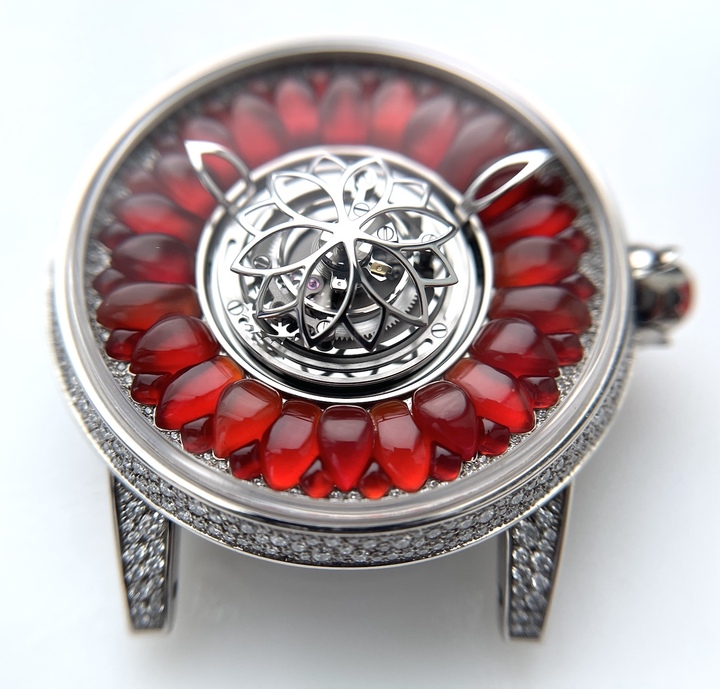 Les 24 pétales, vibrant d'un rouge translucide et taillés individuellement, confèrent au cadran de la Dahlia en or blanc et corail rouge toute son originalité. La cage du tourbillon volant placée au centre est réalisée en or blanc. 144 diamants River pour un total de 0,24 carat épousent le Dahlia né de l'imagination d'Alexandre Beauregard.