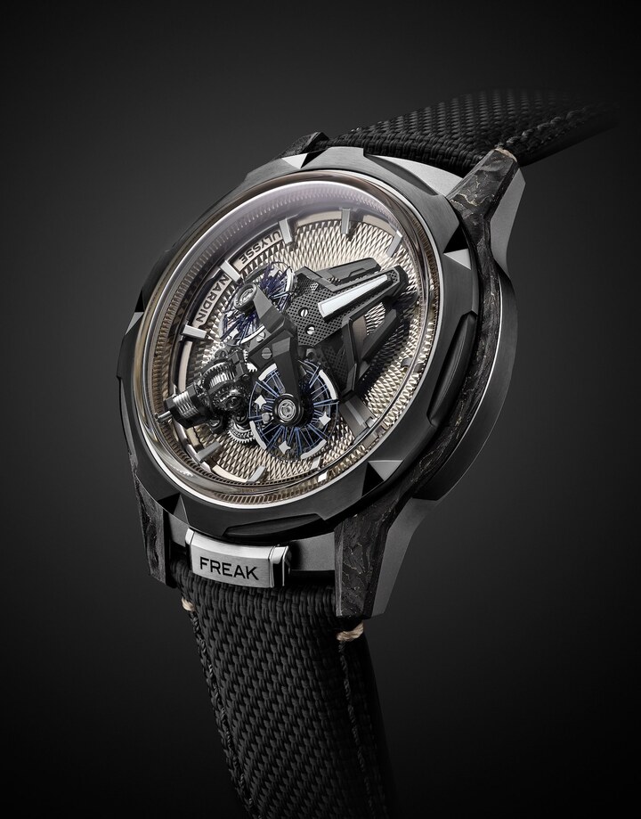 Ulysse Nardin Freak S Nomad (2024), dernière itération de la ligne Freak. Logée dans une boîte en titane de 45 mm de diamètre, les deux échappements inclinés du mouvement en ligne, reliés entre eux par un différentiel, composent une architecture futuriste qui renvoie à l'iconographie cinématographique des films Star Wars ou de la série Star Trek. Le guillochage main aux teintes sablés et au motif diamanté, rend en revanche hommage à la grande tradition horlogère de ce métier d'art.